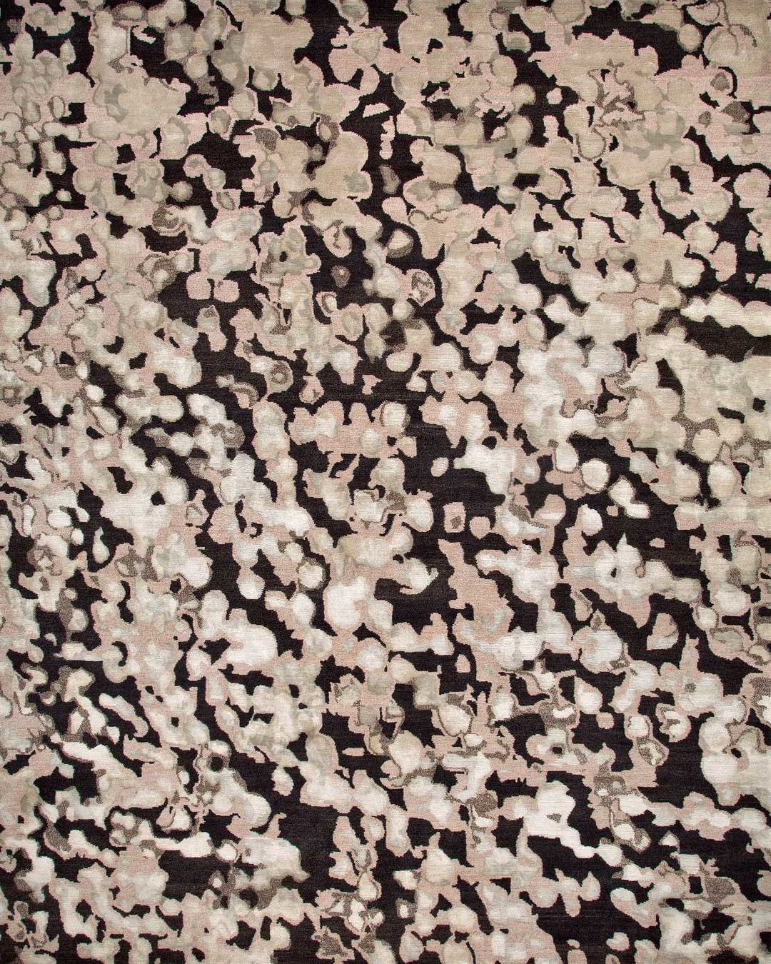 overhead of storm rug by anna carin in abstract charcoal and beige speckle pattern
