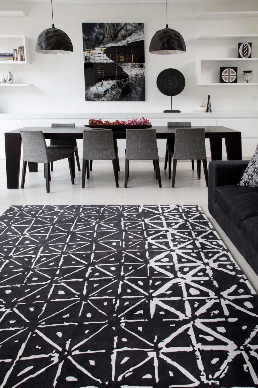 location living room shot of batik rug by akira with a black background and white dots and dashes pattern