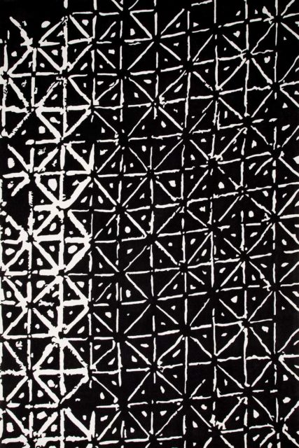 overhead of batik rug by akira with a black background and white dots and dashes pattern