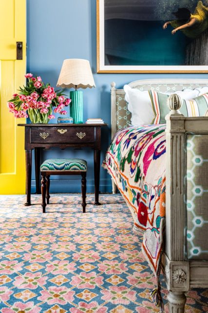 location bedroom shot of flora rug by anna spiro in floral repeat pattern with a blue border