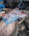 Indigenous Pinkalarta rug in pink and blue colour laid on rocks