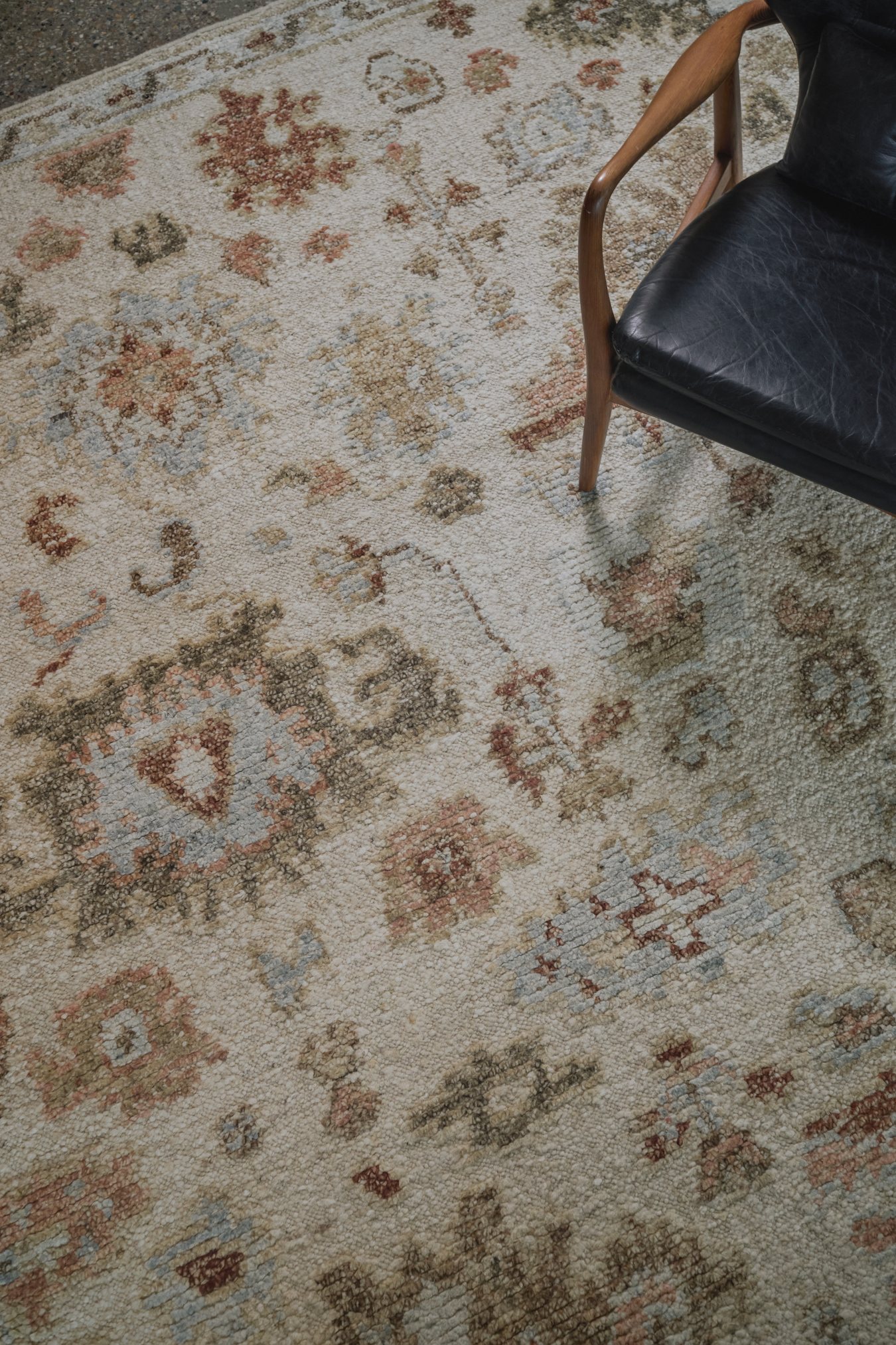 close up image of the Hemen rug from the Oushak Collection, featuring a traditional pattern in cream, soft blue, olive and terracotta.