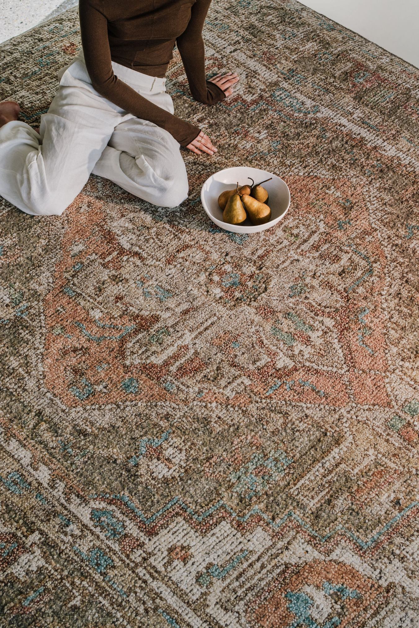 Close-up of the Zaman rug from the Oushak Collection, featuring a traditional pattern in olive, cream, terracotta and turquoise.