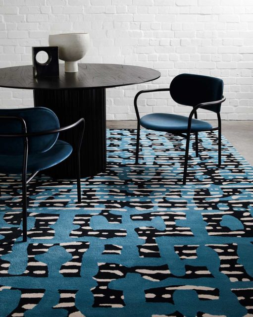 Dining room view of modern, striped Evie rug in blue and navy.
