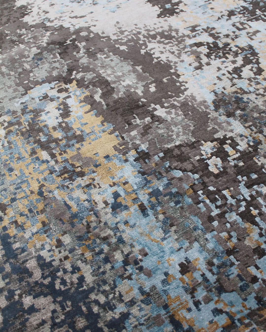 Close up image of abstract Mars handknot rug in blue and gold colour