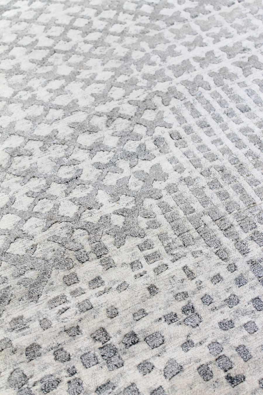 Close up image of patterned Moulin handknot rug in silver colour